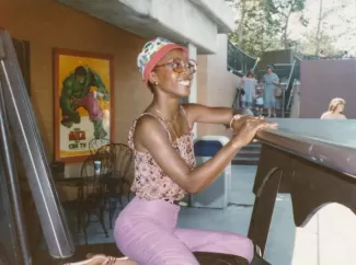 Arlinda posing for a sketched caricature of herself